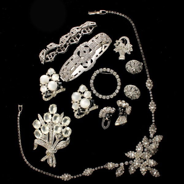 9 WHITE METAL, PASTE COSTUME ITEMS.: COLLECTION OF NINE WHITE METAL, PASTE COSTUME ITEMS. Including one articulated floral design necklace, one pair of blackamoor rhinestone dress clips, one bow and cabochon set of dress clips, one linke