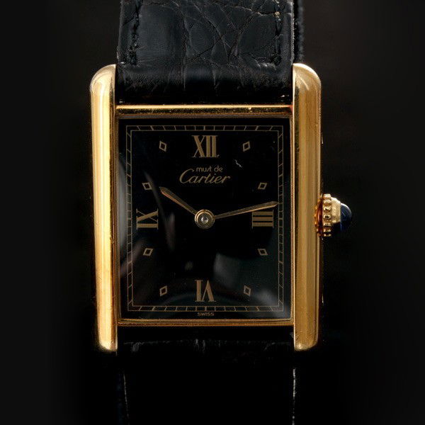 CARTIER TANK, MUST DE VERMEIL WRISTWATCH.: CARTIER TANK, MUST DE VERMEIL WRISTWATCH. Dial: Black, rectangular, outer gold tone minutes track, Roman numeral and diamond shaped hour markers, gold tone baton hands, Cartier. Movement: Quartz (not