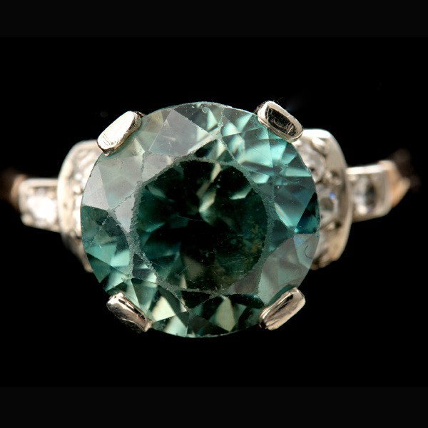 ZIRCON, DIAMOND, 14K TWO TONE GOLD RING.: ZIRCON, DIAMOND, 14K TWO TONE GOLD RING. Centering one round zircon weighing approximately 7.75 cts., accented by eight single-cut diamonds weighing a total of approximately 0.18 ct., prong and bead s