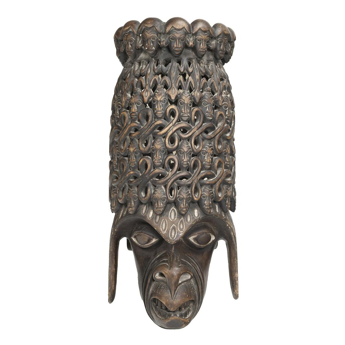 African Oversize Carved Decorative Headdress: African Oversize Carved Decorative Headdress. The monkey like face with white painted eyes, crowned with faces amongst snake latticework repeating pattern, repeating carved head gallery to the top. {A