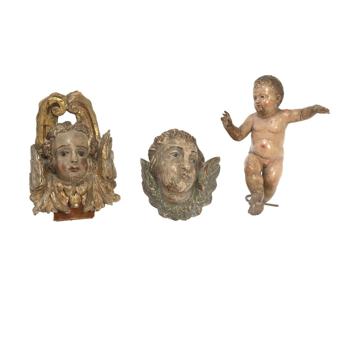 Three Baroque Style Carved Painted Putti Ornaments: Three Baroque Style Carved Painted Putti Ornaments. Comprising: a realistically carved and painted figure of a nude boy of toddler age, seated onto a gilt metal stand; a carved and painted walnut head