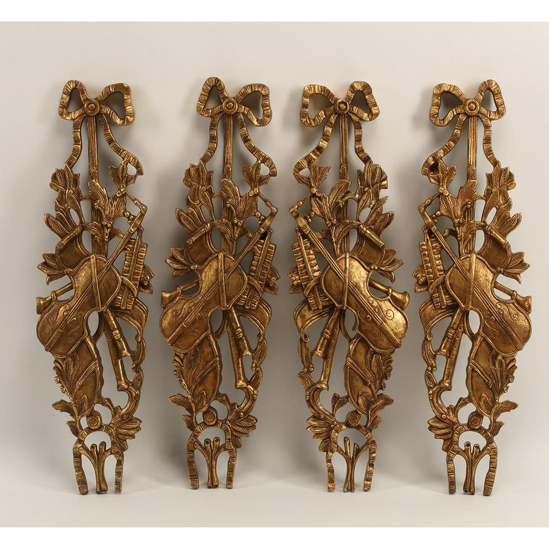 Four Regence Style Giltwood Carvings: Four Regence Style Giltwood Carvings. With musical instrument motif. {Approximate dimensions: 35 1/4 high x 10 inches wide.}. Condition: Patina and rubbing to gilt, one carved ribbon with repair.