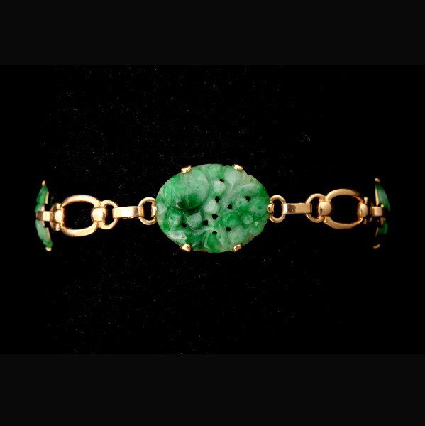 JADE, 14K YELLOW GOLD BRACELET.: JADE, 14K YELLOW GOLD BRACELET. Featuring three oval carved and pierced jadeite plaques measuring approximately 22 x 14 mm, prong set and interspaced by a 14k yellow gold oval link chain forming a 6 i