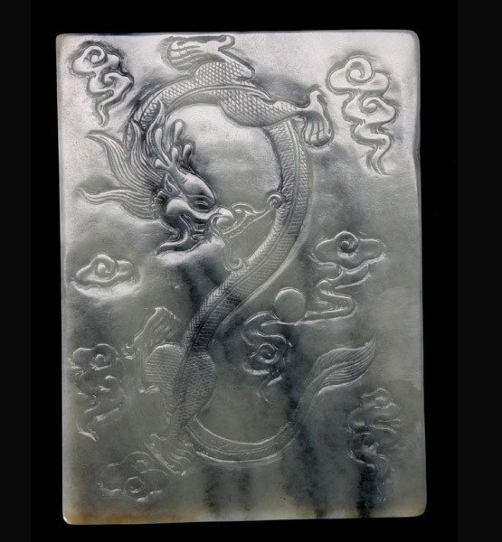 A Carved Jade Ink Box: A Carved Jade Ink Box, of grayish and black hues, the rectangular form incised with a dragon surrounded by swirling clouds {Length: 4 1/2 inches (11.4 cm)}