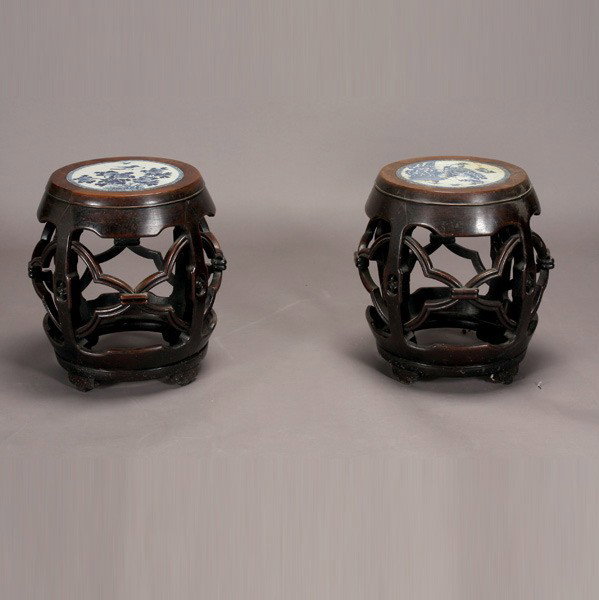 A Pair of Chinese Export Hardwood Stools: A Pair of Chinese Export Hardwood Stools, of barrel form with blue and white porcelain insets depicting flowers and birds {Height: 20 inches (51 cm)} [Cracks and repairs to one of the porcelain insets
