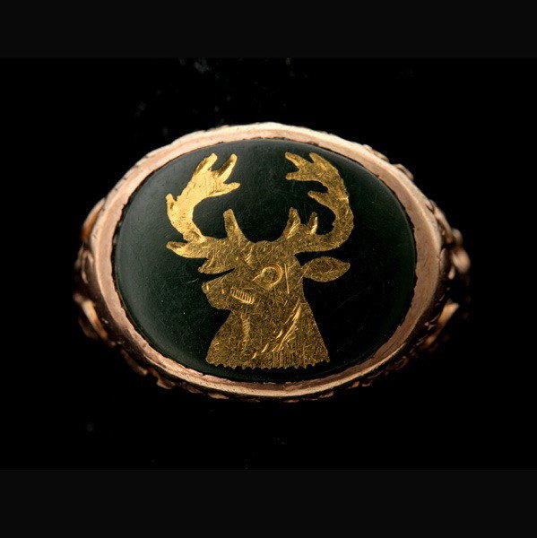 NEPHRITE, 14K YELLOW GOLD RING.: NEPHRITE, 14K YELLOW GOLD RING. Featuring one oval nephrite cabochon depicting a deer in gold inlay, bezel set in a 14k yellow gold mounting. Size 4, 3.6 dwts