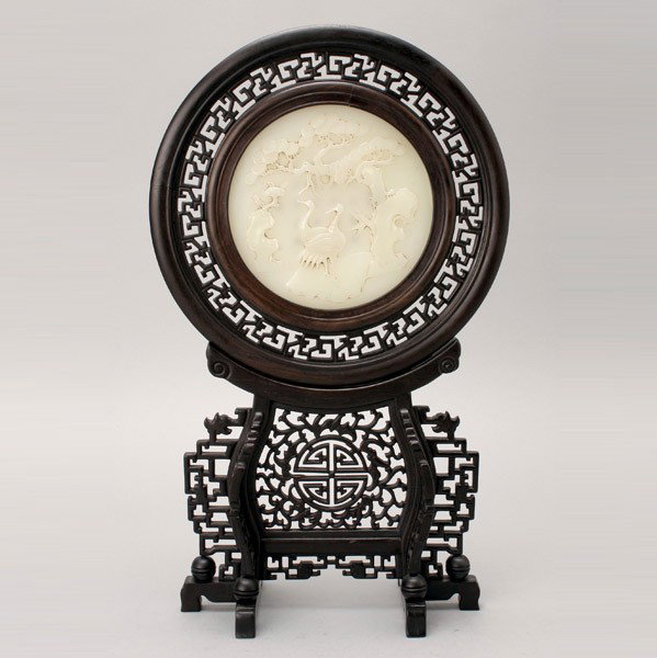 A Circular Table Screen with Decorative Glass Inse: A Circular Table Screen with a Decorative Glass Inset, depicting a pair of cranes reversed by an inscription, surrounded by a carved wood frame and fitted stand {Height: 17 inches (43.2 cm)}