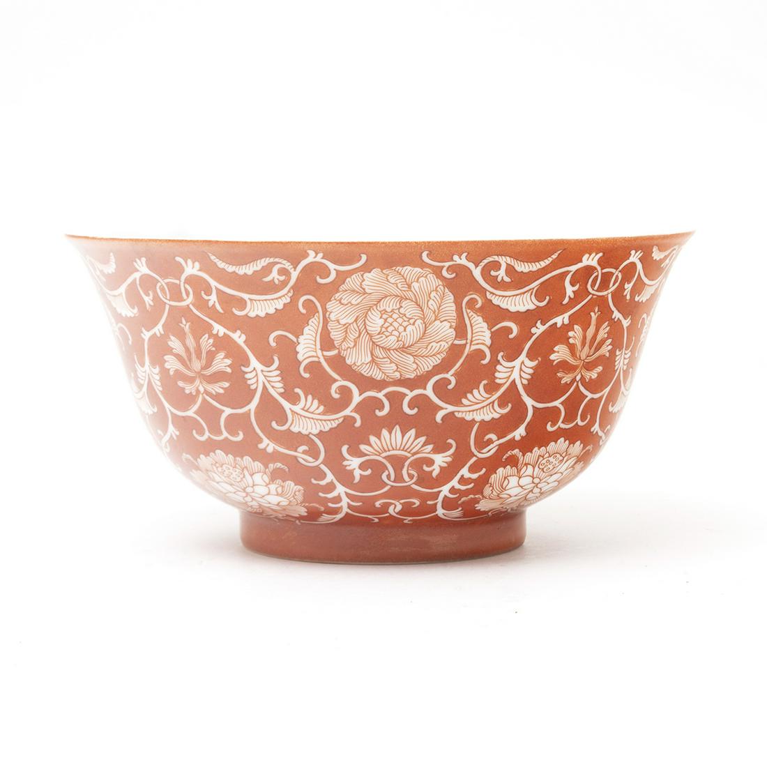 A Chinese Coral Ground Reserve Decorated 'Lotus' Bowl: A Chinese Coral Ground Reserve Decorated 'Lotus' Bowl. Of deep rounded sides rising from a short foot to a flared rim, the exterior covered in orange-red glaze and decorated in reserve with stylized l