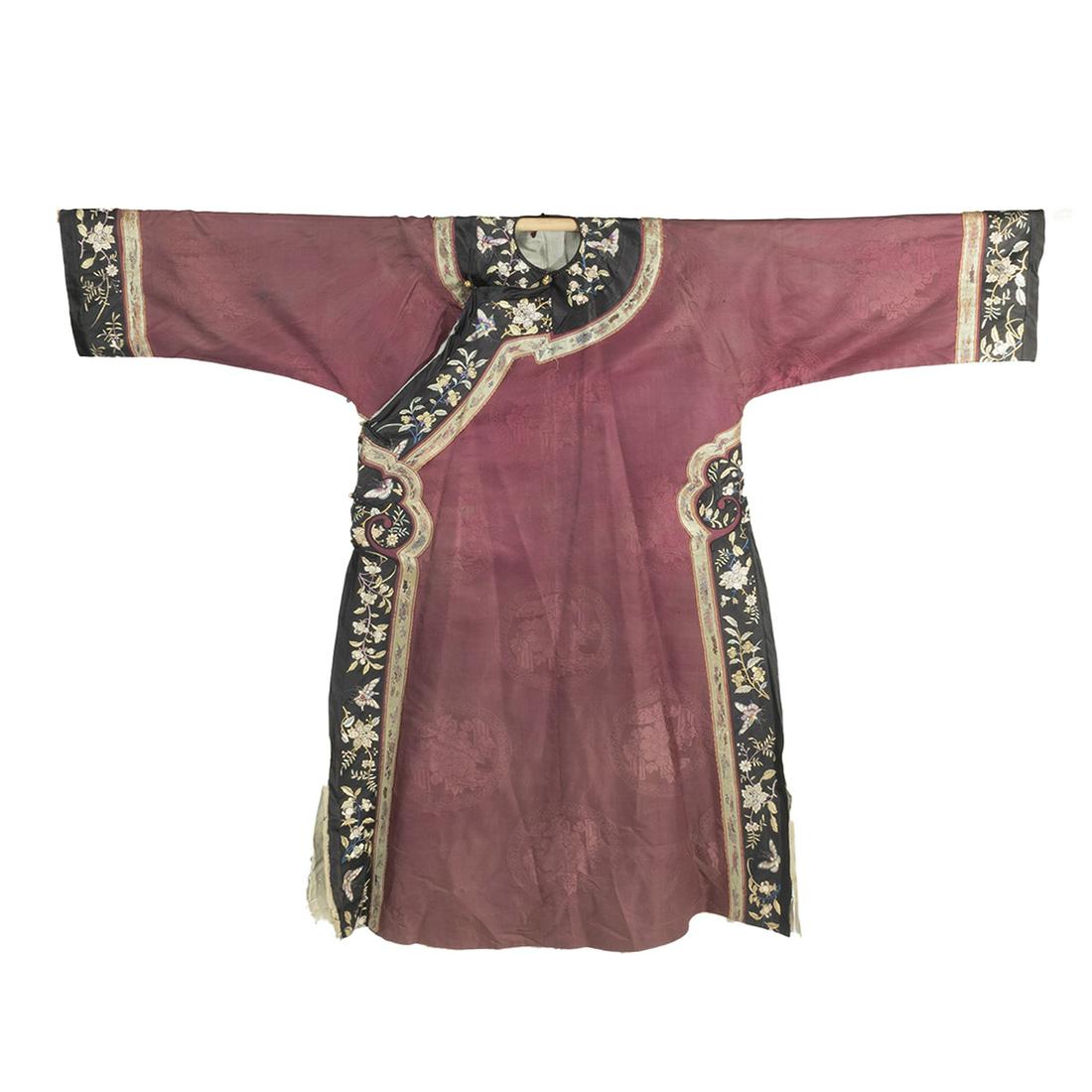 A Chinese Chestnut Ground Silk Embroidered Qipao: A Chinese Chestnut Ground Silk Embroidered Qipao. Finely tailored with a right side opening, the black borders and sleeve bands are embroidered with butterflies and various flowering sprigs, the chest