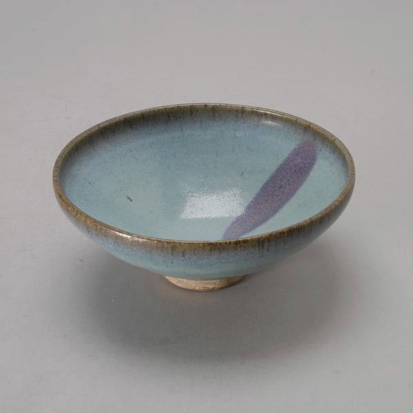 A Jun Ware Type Bowl: A Jun Ware Type Bowl, Heavily potted with steep curving sides, the interior painted with a thick pale blue glaze with a single purple splash. Ming Dynasty or Later, Diameter: 7 1/8 inches (18.2 cm) No