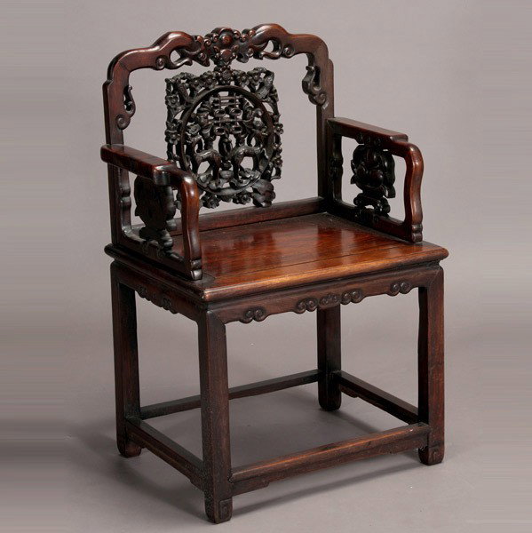 A Carved Hardwood Chair, 19th/20th Century: A Carved Hardwood Chair, The top rail carved as a bat dangling a double-happiness character symbol surrounded by prunus blossoms, birds, deer and more bats, the arm openings carved with peaches attach