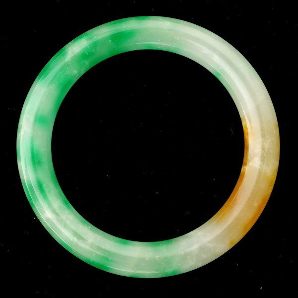 JADE BRACELET.: JADE BRACELET. The carved jadeite bangle measures approximately 4.00 mm in width and 55.00 mm internal diameter. Note: Internal fissures.