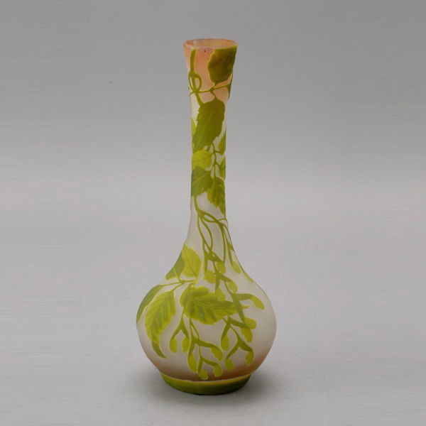 Gallé Cameo Cut Glass Vase: Gallé Cameo Cut Glass Vase, Circa 1910, the bottle form with a translucent green cushioned foot, the pale salmon ground shading to clear, overlaid with sprays of leaves spreading to stems of young le