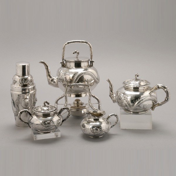 Chinese Export Silver Four Piece Tea Service: Chinese Export Silver Four Piece Tea Service, Wing Chun, Hong Kong: each piece with repousse figures of dragons chasing the eternal pearl; comprising a tea kettle, initialed (height 10 1/4 inches); a 