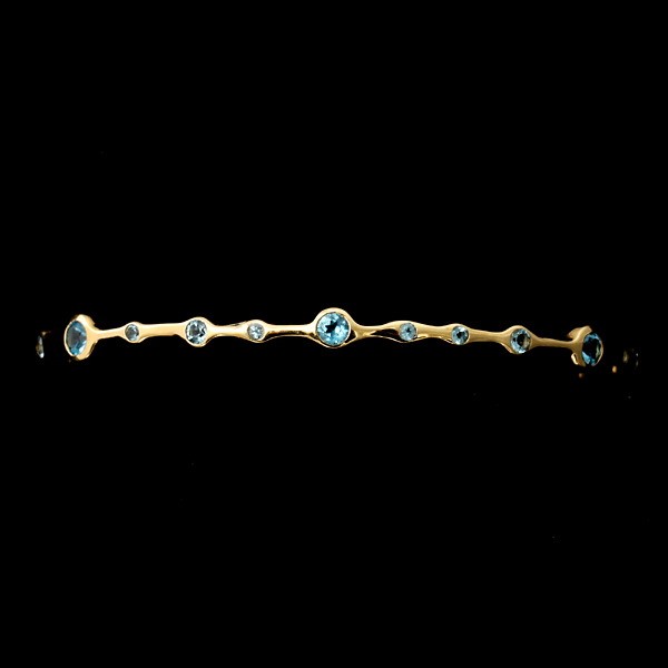 IPPOLITA TOPAZ, 18K YELLOW GOLD BANGLE.: IPPOLITA TOPAZ, 18K YELLOW GOLD BANGLE. The bracelet features twenty-three round blue topaz, bezel set in 18k yellow gold. Signed Ippolita. 6.60 dwts
