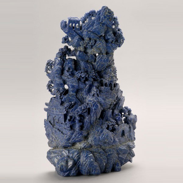 A Massive Carved Lapis Lazuli Landscape: A Massive Carved Lapis Lazuli Landscape, of vertical format depicting a pagoda nestled within a cliff side surrounded by pine trees and travelers {Height: 19 3/4 inches (50.2 cm)} [Small nicks and chi