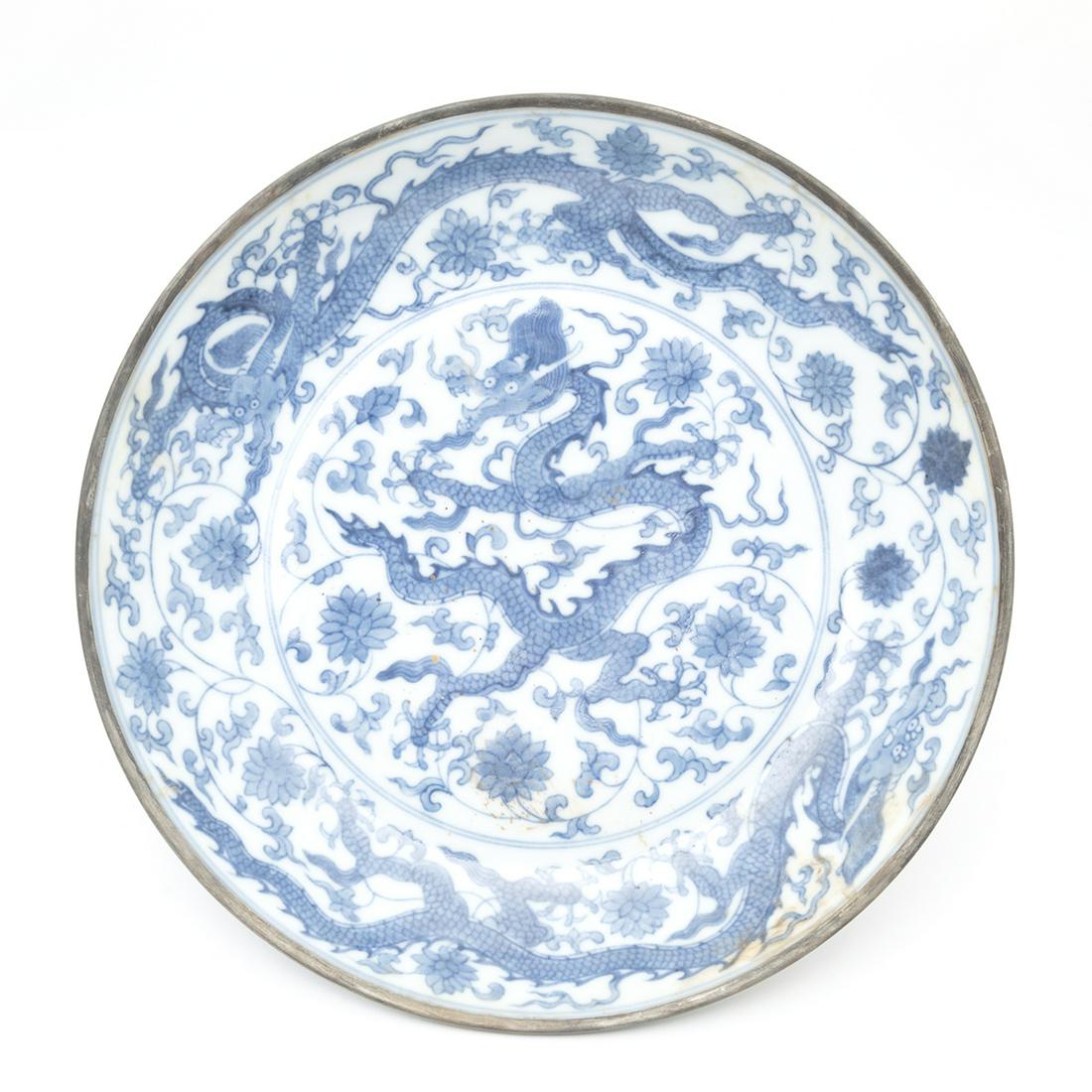 Chinese Blue and White 'Dragon' Dish: Chinese Blue and White 'Dragon' Dish. Of deep rounded sides rising from a tapered foot to a flared rim, an interior medallion painted with a sinuous dragon amid lotus scrolls with two striding dragons