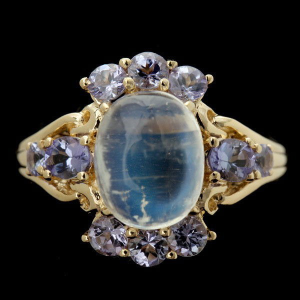 MOONSTONE, TANZANITE, 14K YELLOW GOLD RING.: MOONSTONE, TANZANITE, 14K YELLOW GOLD RING. Centering one oval moonstone cabochon measuring approximately 10 x 8 mm accented by eight round-cut and two oval-cut tanzanites weighing a total of approxim