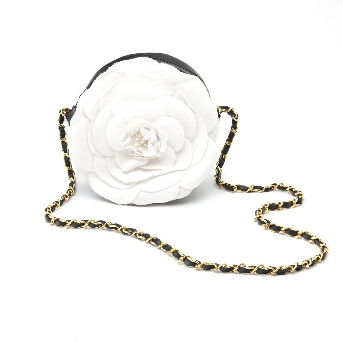 Chanel Round Black Quilted Bag with White Camelia: Chanel Round Black Quilted Bag with White Camelia. With I. Magnin retail box. {Approximate dimensions: 7 inches diameter, strap drop 16 1/2 inches.}. Condition: Some wear throughout. White flower with