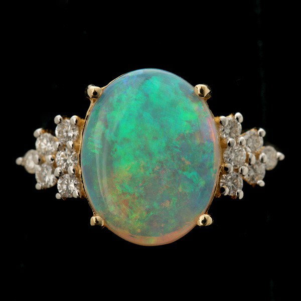 OPAL, DIAMOND, 14K YELLOW GOLD RING.: OPAL, DIAMOND, 14K YELLOW GOLD RING. Featuring one oval opal cabochon, measuring approximately 13 x 10 x 2 mm, flanked by twelve full-cut diamonds weighing a total of approximately 0.35 ct., set in a 