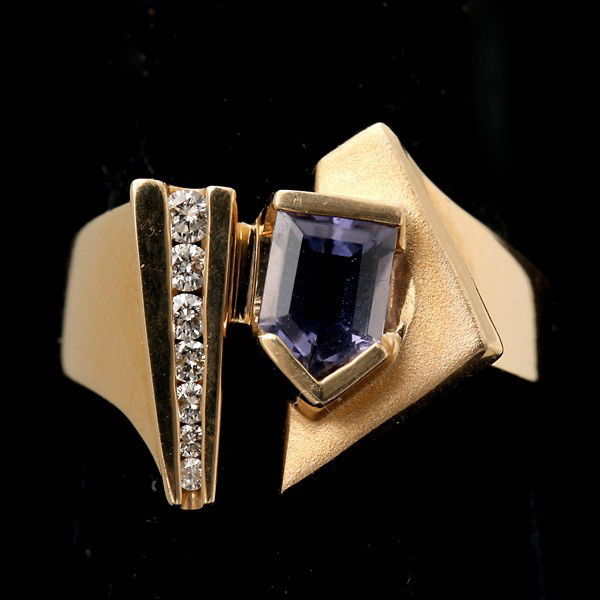 TANZANITE, DIAMOND, 18K YELLOW GOLD RING.: TANZANITE, DIAMOND, 18K YELLOW GOLD RING. Featuring one trapazoid shaped tanzanite, weighing approximately 0.80 ct., accented by seven full-cut diamonds weighing a total of approximately 0.15 ct., set