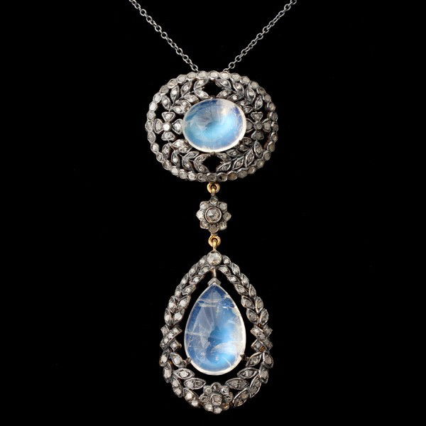 MNSTONE, DIA., SILVER TOPPED, 9K Y/G PEND-NECKLACE: MOONSTONE, DIAMOND, SILVER TOPPED, 9K YELLOW GOLD PENDANT-NECKLACE. Featuring an oval floral open work mounting enhanced with rose-cut diamonds and centering an oval moonstone cabochon measuring appro