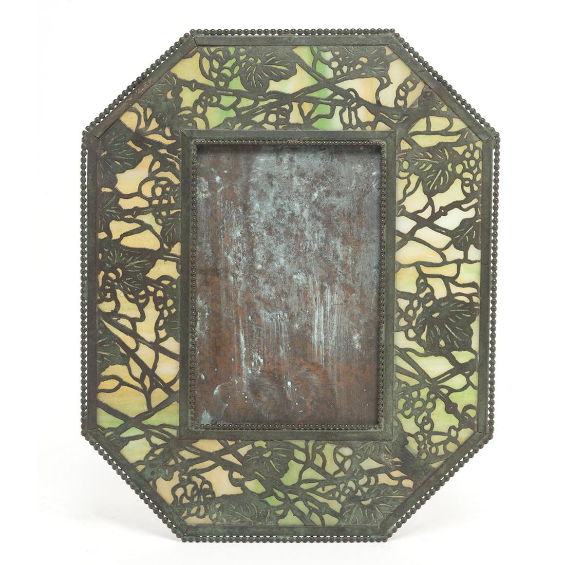 Riviere Studios Bronze and Glass Grapevine Frame: Riviere Studios Bronze and Glass Grapevine Frame. Octagonal frame, bronze grapevine motif overaly green slag glass. 'RIVIERE STUDIOS NEW YORK' to reverse. First quarter 20th century. {Approximate dime