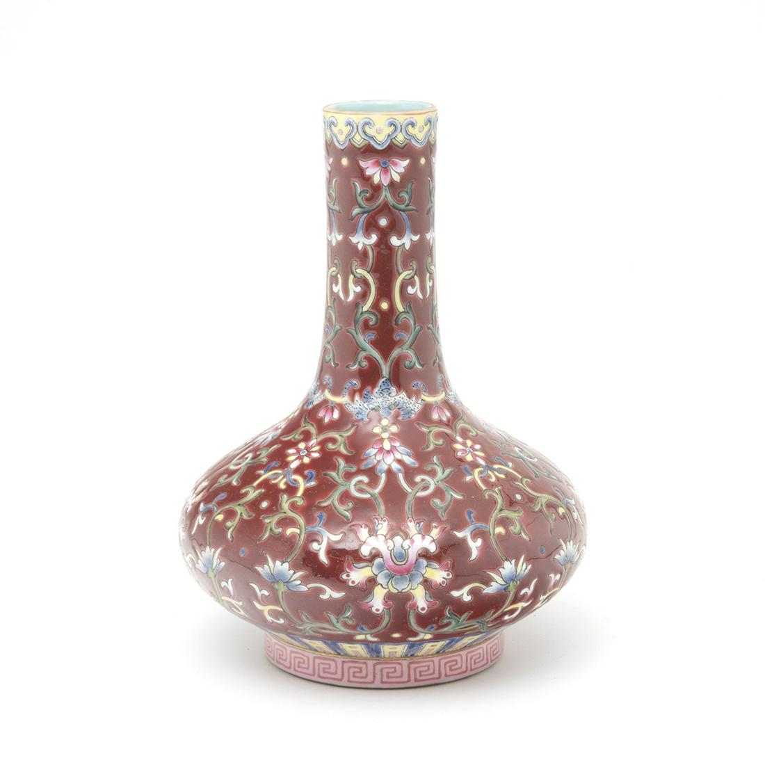 A Chinese Ruby Red Porcelain 'Lotus' Bottle Vase: A Chinese Ruby Red Porcelain 'Lotus' Bottle Vase. Of compressed globular body and a cylindrical neck, the ruby-red ground decorated with scrolling lotus between stylized ruyi and li wan bands, the bas