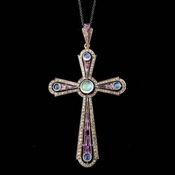 MOONSTONE, DIA., AMETH., SILVER GILT CROSS PENDANT: MOONSTONE, DIAMOND, AMETHYST, SILVER GILT CROSS PENDANT. Designed as a cross featuring five round moonstone cabochons, accented by fourteen calibre-cut amethysts weighing a total of approximately 2.00