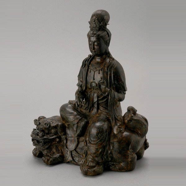 A Mixed Metal Manjusri: A Mixed Metal Manjusri, the bodhisattva shown seated in lalitasana atop a recumbent lion with curly mane and a cloth draped over its back, the figure holding a ruyi scepter in the right hand and with 