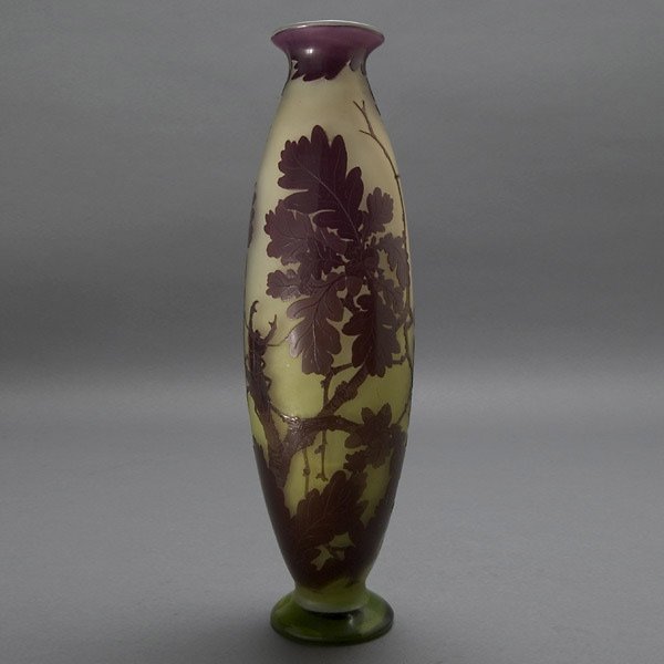 Gallé Cameo Glass Vase, circa 1910: Gallé Cameo Glass Vase. The trumpet form cut with oak branches, sprays of acorns, and an exploring pincher bug, shaded from greens to purple on a gray opalescent ground, raised script signature "Gall