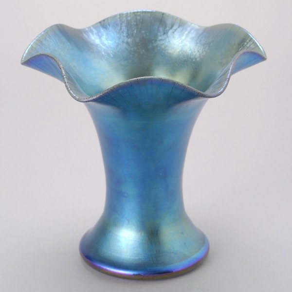 Steuben Blue Aurene Glass Vase: Steuben Blue Aurene Glass Vase. The blue tapered cylindrical form spreading to a rounded foot and a flaring ruffle rim, with stretch iridescence and green and violet highlights, etched "723 Aurene" in