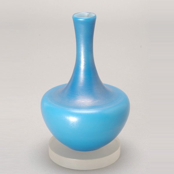 Tiffany Studios Favrile Turquoise Bud Vase: Tiffany Studios Favrile Turquoise Bud Vase. The oil lamp form with an hour glass cylindrical neck in a turquoise iridescent glass, the dark turquoise neck spreading to an ovoid base shading to a milky