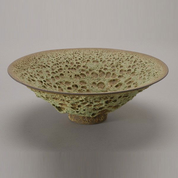 James Lovera Green and Brown Crater Bowl: James Lovera (American Born 1920) The wide brim stoneware bowl with an allover green and brown crater glaze raised on a brown slip glazed foot, inscribed on recessed base "Lovera". Massive Green Crate
