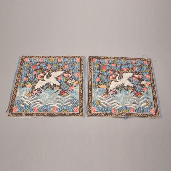 A Pair of Kesi-Woven Civil Rank Badges: A Pair of Kesi-Woven Civil Rank Badges, Both badges woven to depict the first Civil Rank crane amidst cloud florets, bats and scrolling gilt flowers, all above crashing waves and jagged rocks supporti
