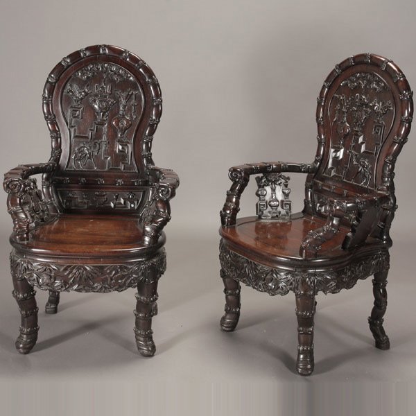 A Pair of Carved Hardwood Armchairs, Republic: A Pair of Hardwood Armchairs, Both heavily constructed and elaborately carved with antiquities and auspicious objects on the solid back splat and spandrels, further decorated with images of bats, cran