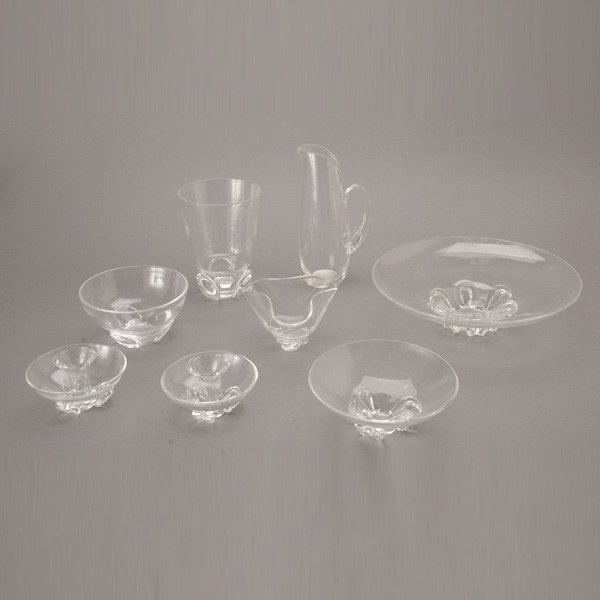 Collection of 8 Steuben Glass Pieces: Suite of Eight Steuben Tablewares: four bowls (diameter of largest 13 inches); a pitcher (height 10 inches); a pair of candlesticks; and a vase (height 7 1/2 inches)
