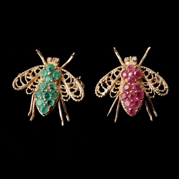 2 RUBY, ENAMEL, 14K YELLOW GOLD BEE BROOCHES.: COLLECTION OF TWO RUBY, ENAMEL, 14K YELLOW GOLD BEE BROOCHES. Including one bee brooch featuring round-cut rubies and one featuring round-cut emeralds, both set in 14k yellow gold. 2.2 dwts