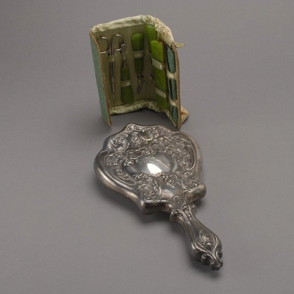 Dresser Mirror and 7 piece Nail set: Derby Silver Plate Mounted Dresser Mirror; together with a cased celluloid seven piece nail set with faux jade handles {Height of mirror 10 1/4 inches}
