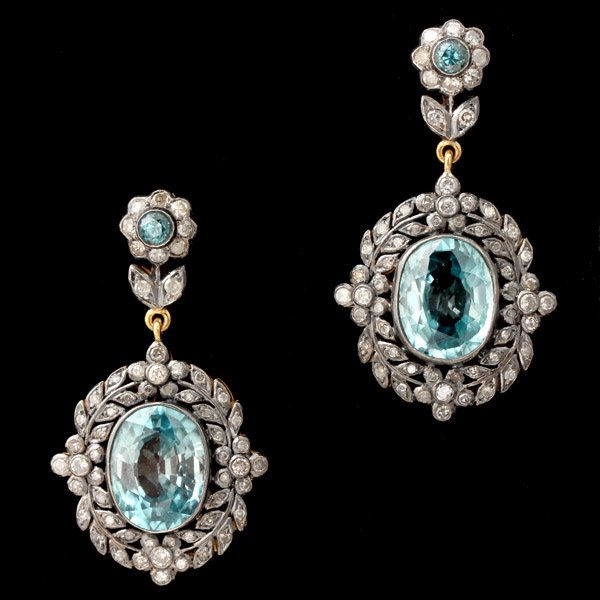 BLUE ZIRCON, DIAMOND, SILVER GILT EARRINGS.: BLUE ZIRCON, DIAMOND, SILVER GILT EARRINGS. Each earring features one oval blue zircon accented by round diamonds, suspended from posts, accented by one round blue zircon accented by ten round diamond