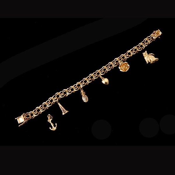 14K YELLOW GOLD CHARM BRACELET.: 14K YELLOW GOLD CHARM BRACELET. Featuring four 14k yellow gold charms described as follows: a rose, a heart, a pineapple, the Eiffel tower suspended from a 14k yellow gold double link 7 1/2 inch brace