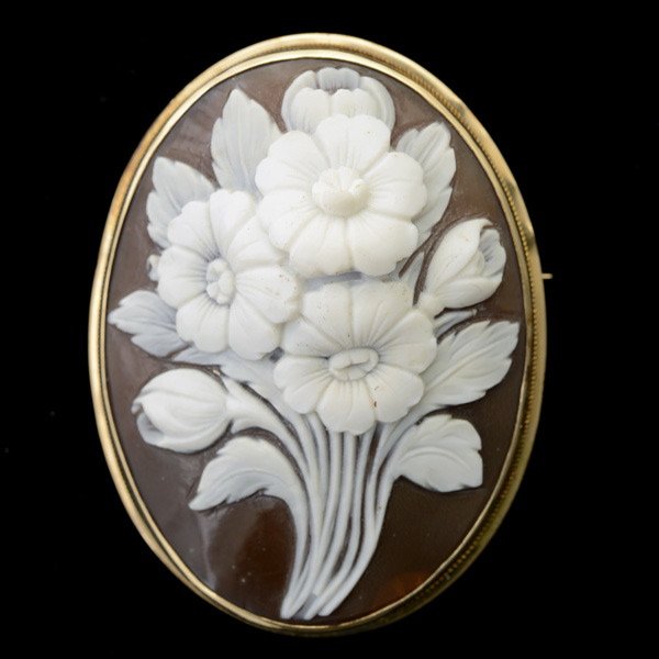 SHELL CAMEO, 14K YELLOW GOLD BROOCH.: SHELL CAMEO, 14K YELLOW GOLD BROOCH. Featuring one oval shell cameo measuring approximately 45 x 30 mm depicting flowers, set in a 14k yellow gold mounting. 5.9 dwts