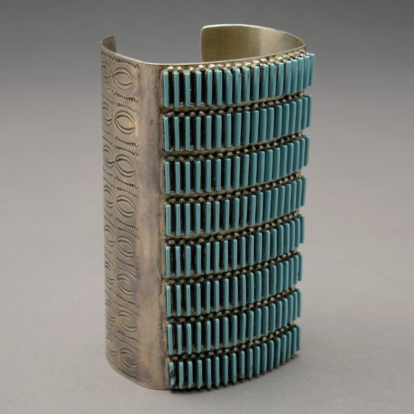 STERLING SILVER, TURQUOISE, NEEDLEPOINT BANGLE: ZUNI, STERLING SILVER, TURQUOISE, NEEDLEPOINT BANGLE. Featuring eight rows of needlepoint turquoise, bezel set and enhanced by a silver bead border, further enhanced by stamp work designs, signed R.L.