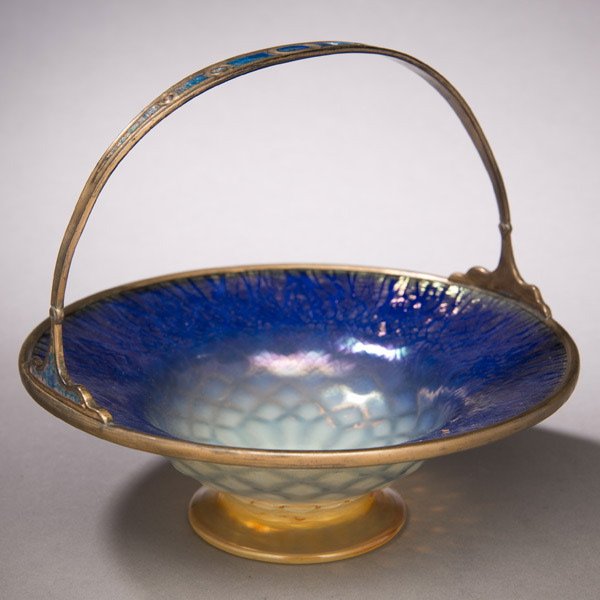 Tiffany Studios Cake Dish: Tiffany Studios Cake Dish. Favrile glass, with enamelled gilt-metal mount impressed LOUIS C. TIFFANY FURNACES INC. 501, with the firm's logo. Diameter 7 7/8 inches (20 cm.). This cake dish is pictured