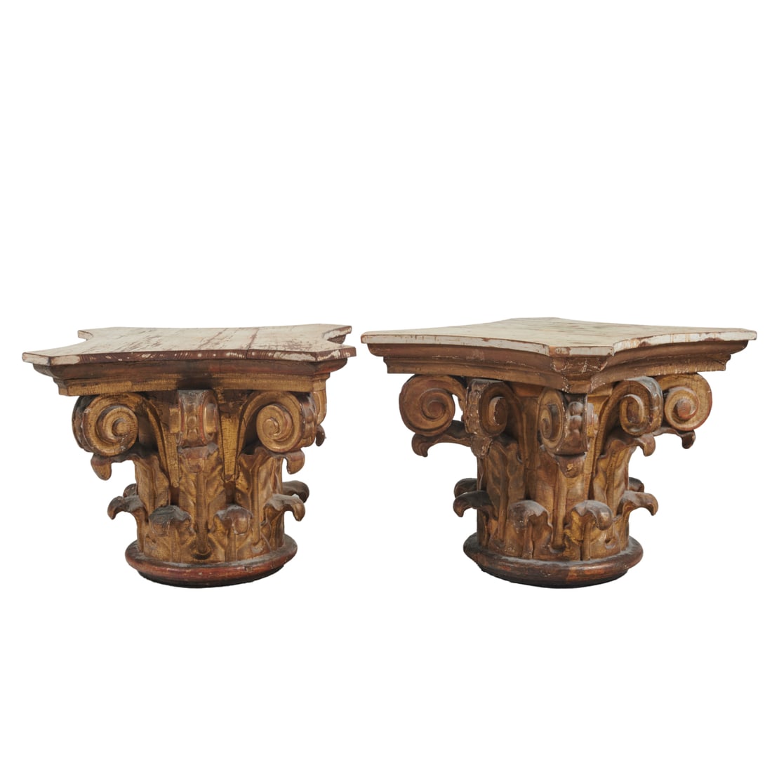 Pair Giltwood Romanesque Corinthian Capitol Table Bases: Pair of Giltwood Romanesque Corinthian Capitol Table Bases. Giltwood capitals with patinated white painted tops. {Approximate dimensions: 22 3/4" high x 29 1/2" wide x 29" deep.}. Provenance: from the