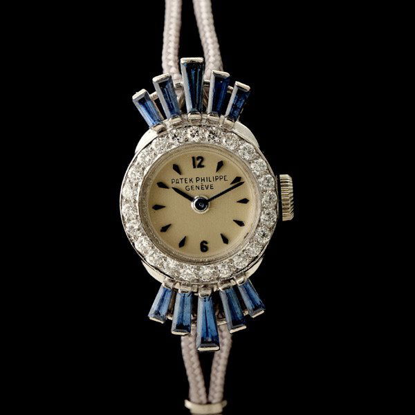 PATEK PHILIPPE DIA., SAPH., PLAT., METAL WATCH.: LADIES PATEK PHILIPPE DIAMOND, SAPPHIRE, PLATINUM, METAL WRISTWATCH. DIAL: Round, silver, blue diamond shaped, hour markers, blued baton hands, Patek Philippe Geneve. MOVEMENT: Eighteen jewels, adjust