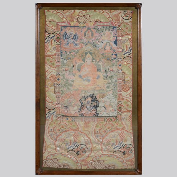 A Fine Woven Tibetan Thangka, 19th C: A Fine Woven Tibetan Thangka, With a central seated lama before an altar table, flanked by acolytes and demons amongst clouds and flames, brocade silk mount, framed and glazed. 19th Century, 47 x 25 i