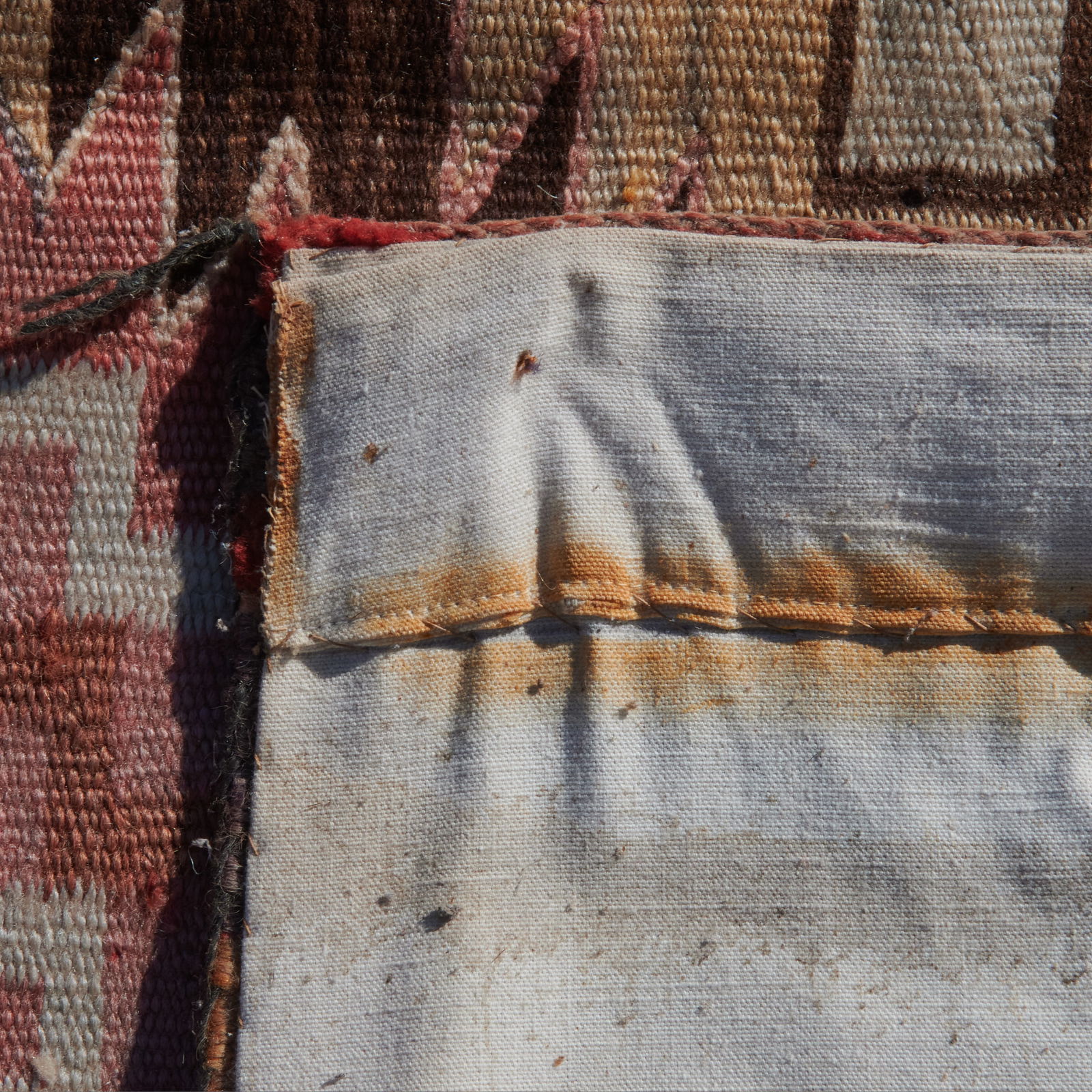 Dine Navajo Rug: Dine Navajo Rug. Geometric motif woven in red, cream, browns, beige, gray; with linen backing. {Approximate dimensions: 4'7" x 3'1".}. Condition: Fading and wear throughout. Repairs.