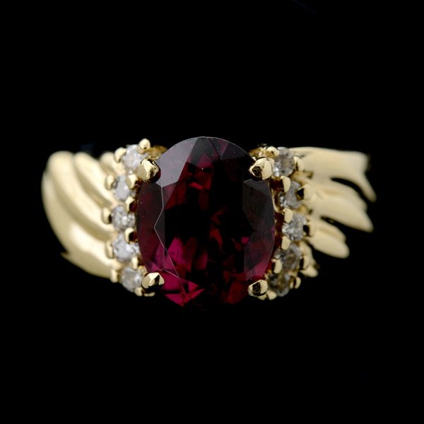 GARNET, DIAMOND, 14K YELLOW GOLD RING.: GARNET, DIAMOND, 14K YELLOW GOLD RING. Centering one oval-cut garnet weighing approximately 2.00 cts., accented by ten full-cut diamonds weighing a total of approximately 0.10 ct., set in a 14k yellow