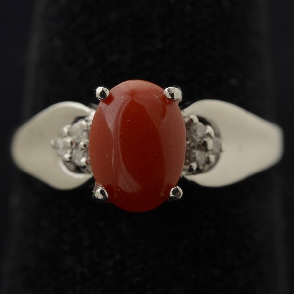 *CORAL, DIAMOND, 14K WHITE GOLD RING.: *CORAL, DIAMOND, 14K WHITE GOLD RING. Featuring one oval coral cabochon, accented by six full-cut diamonds weighing a total of approximately 0.05 ct., set in a 14k white gold mounting. Size 6 1/2, 1.6